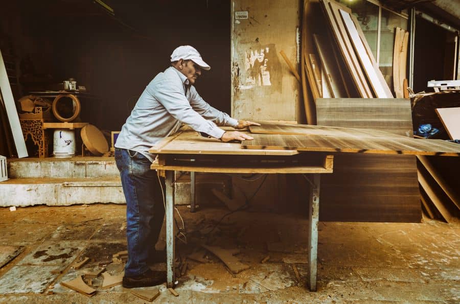 Menuisier travaillant une pièce de bois à l’établi